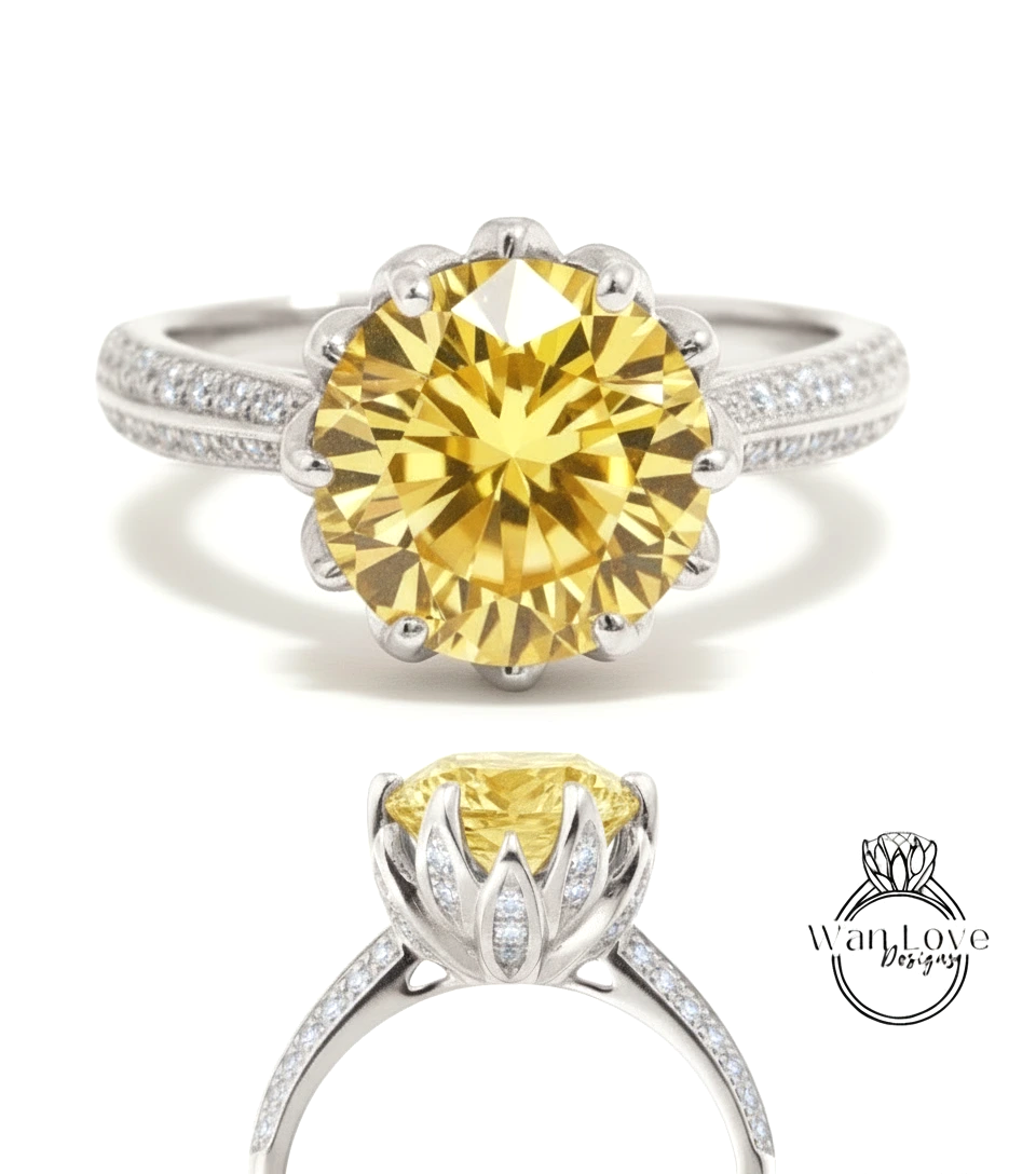 A stunning yellow diamond engagement ring with a large central diamond surrounded by smaller diamonds on either side, set in a silver band.