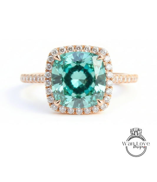 A stunning ring featuring a large, square-cut green gemstone surrounded by a halo of smaller diamonds set in a gold band.