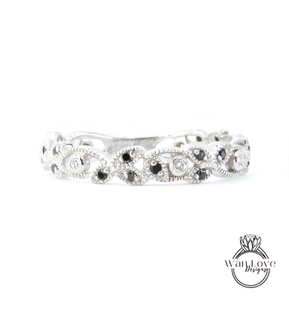 A silver ring with a decorative design featuring black and white stones.