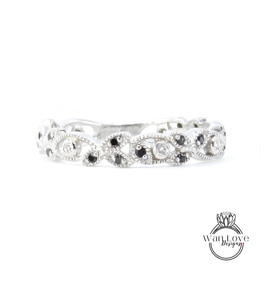 A silver ring with a decorative design featuring black and white stones.