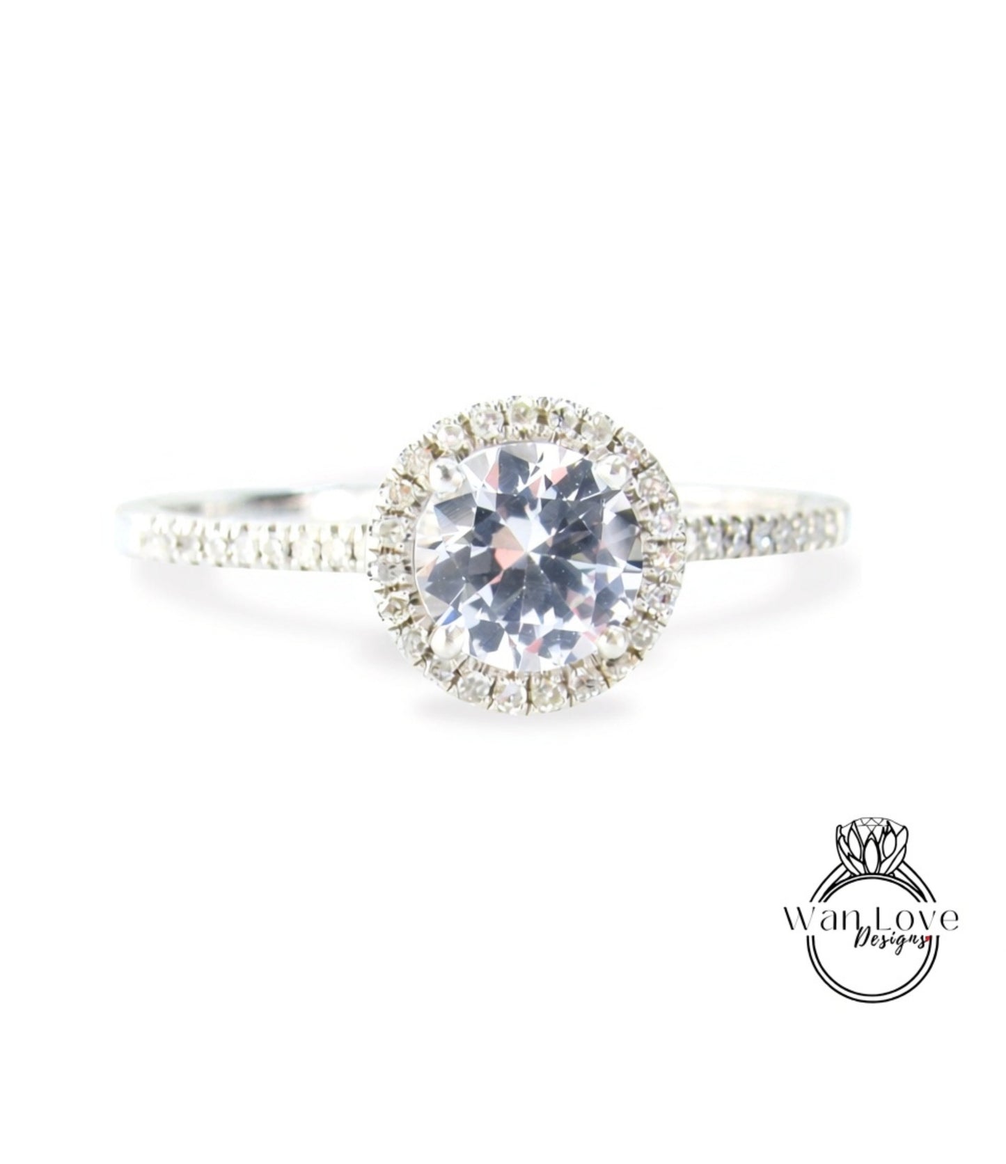 A close-up view of a diamond engagement ring with a large central diamond surrounded by smaller diamonds, set in a halo of smaller diamonds.