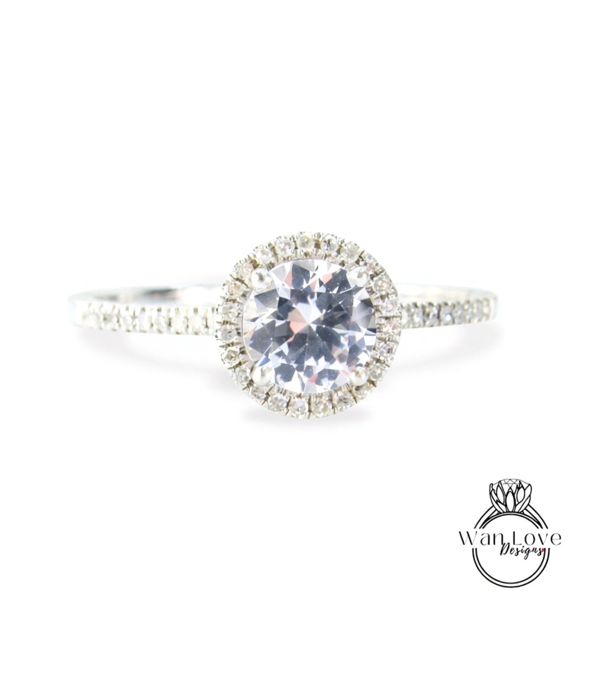 A close-up view of a diamond engagement ring with a large central diamond surrounded by smaller diamonds, set in a halo of smaller diamonds.