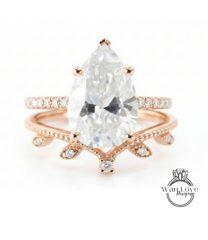 A close-up image of a beautiful engagement ring featuring a large pear-shaped diamond set in a rose gold band with a leaf-shaped accent.