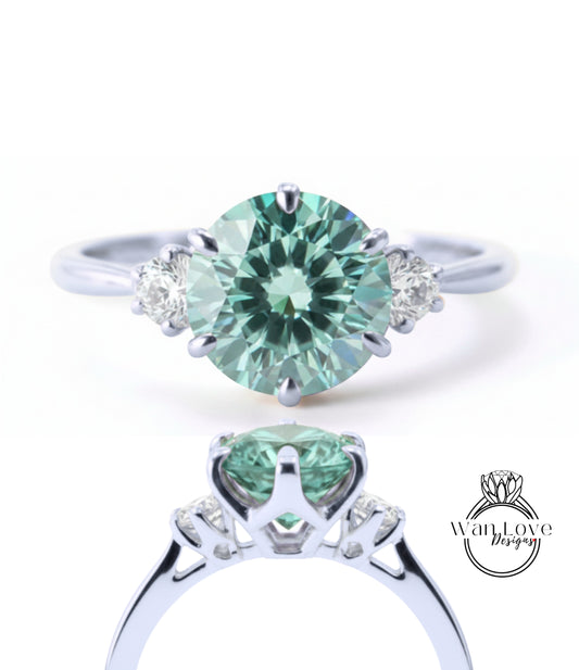 A silver ring with a large, round green gemstone set in the center, surrounded by smaller diamonds.