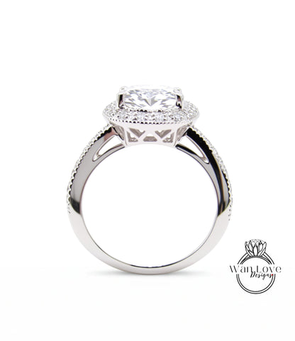 A close-up of a silver engagement ring with a large central diamond surrounded by smaller diamonds, set in a halo of smaller diamonds.