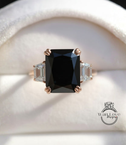 A close-up image of a gold ring with a large black diamond as the centerpiece, surrounded by smaller diamonds.