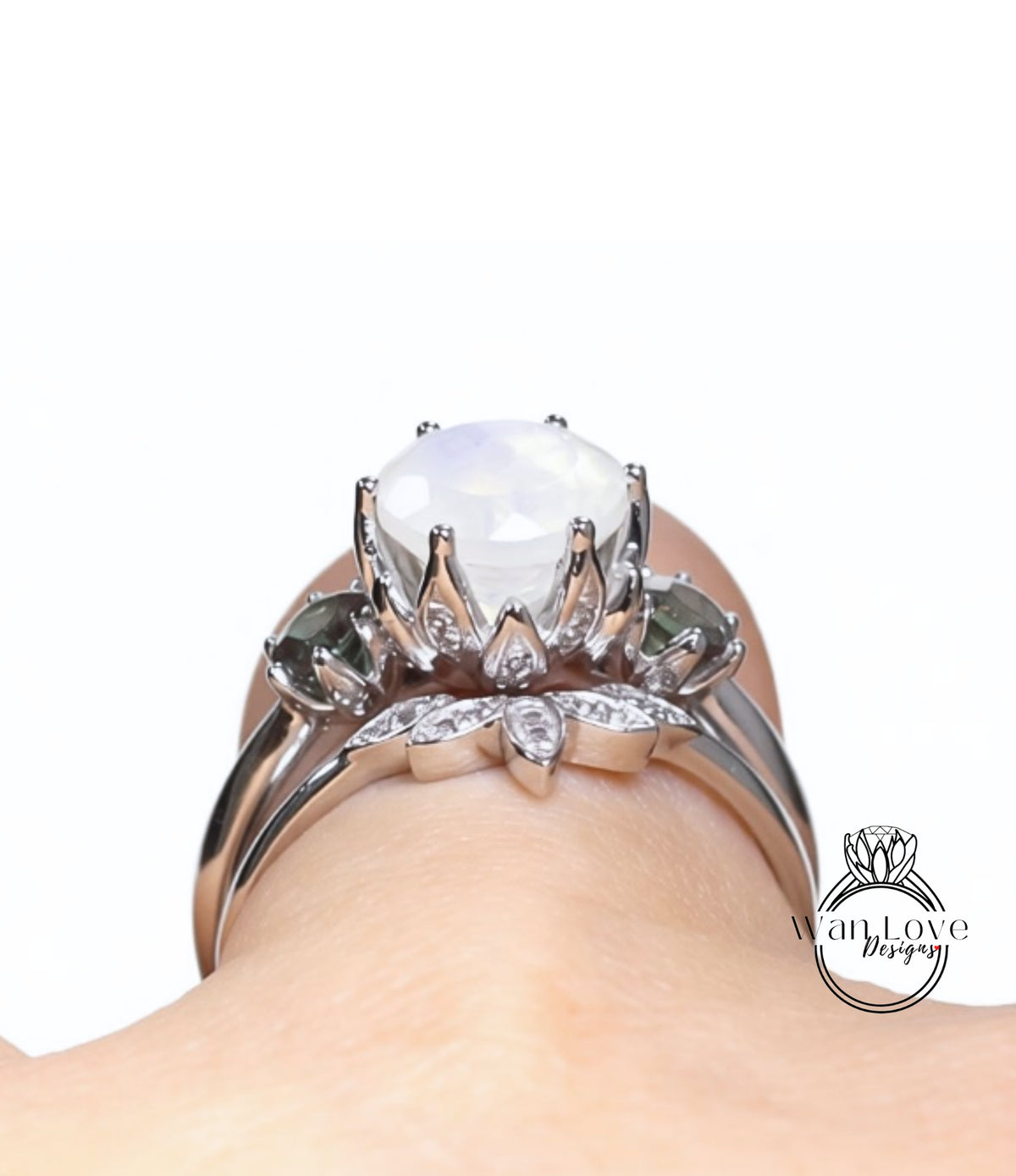 A close-up view of a silver ring with a large white gemstone, featuring a floral design and smaller gemstones.