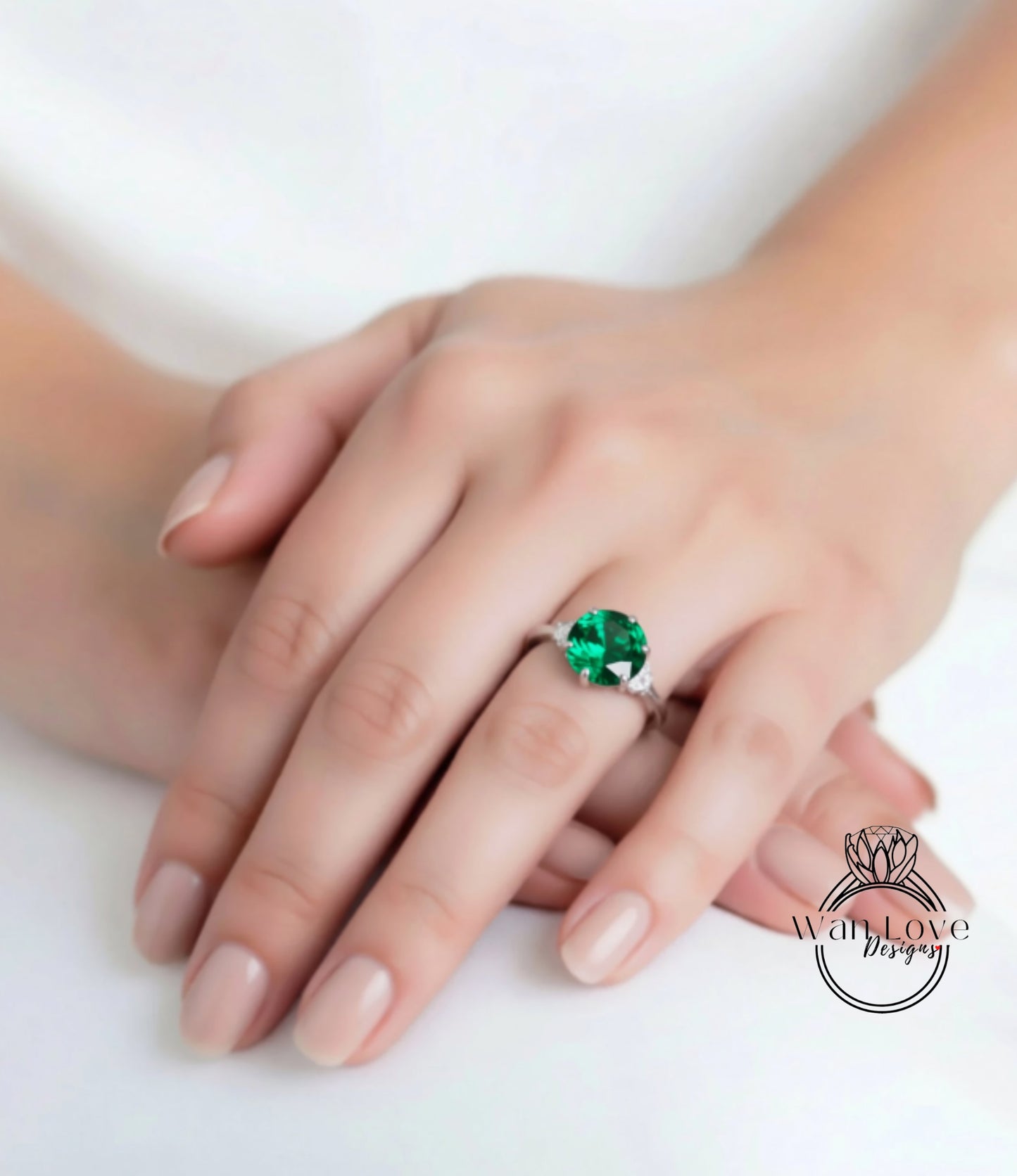 A close-up of a person's hand wearing a large, green gemstone ring.