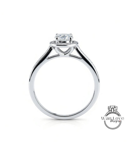 A silver engagement ring with a large central diamond and a halo of smaller diamonds around the center stone.
