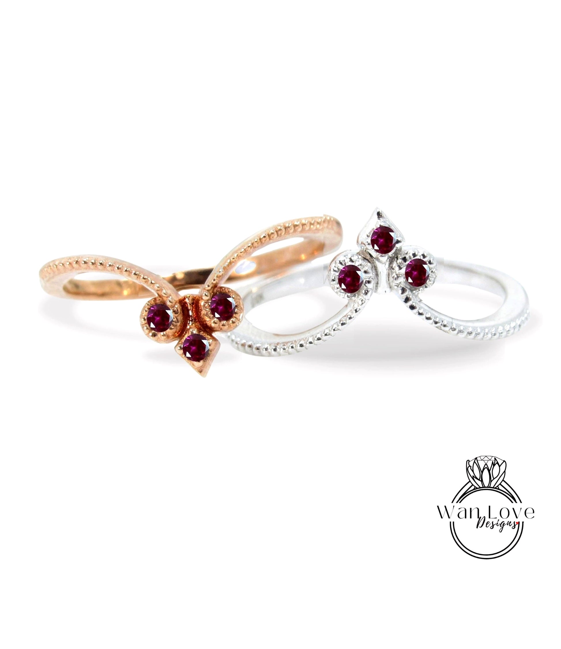 two rings with gemstones, one silver and one gold, set against a white background.