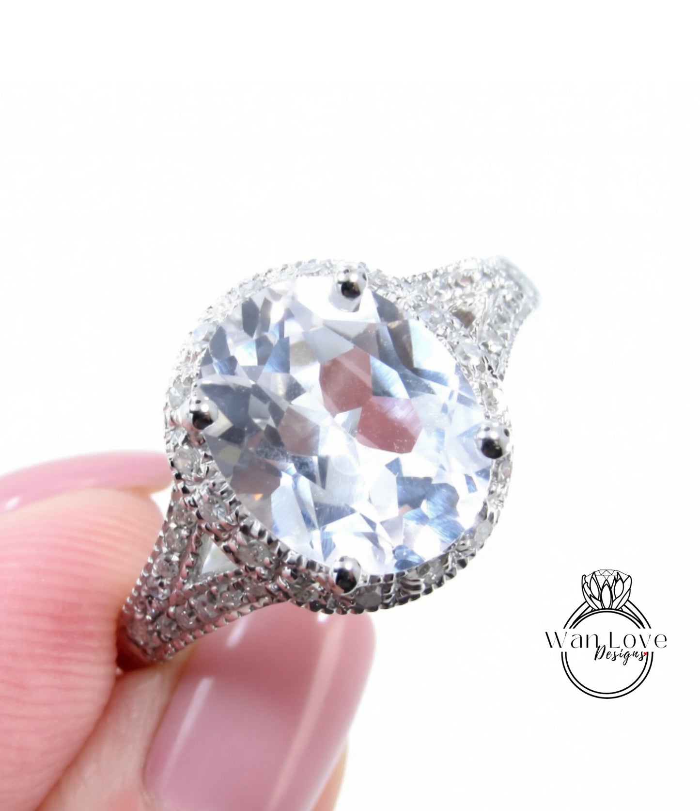 A close-up image of a person's hand holding a large, sparkling diamond ring with a halo of smaller diamonds around the center stone.