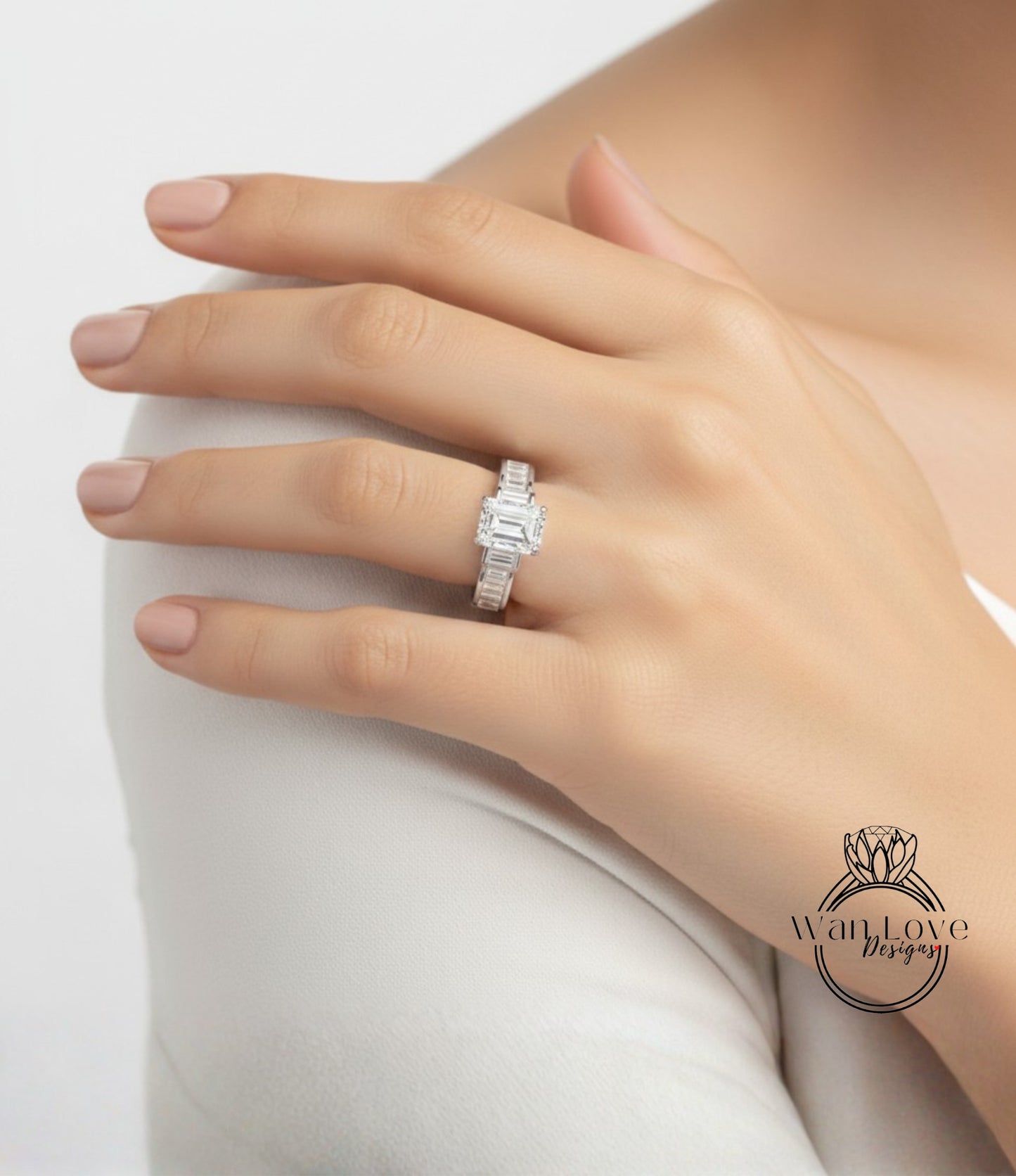 A close-up of a person's hand wearing a diamond engagement ring on the ring finger.