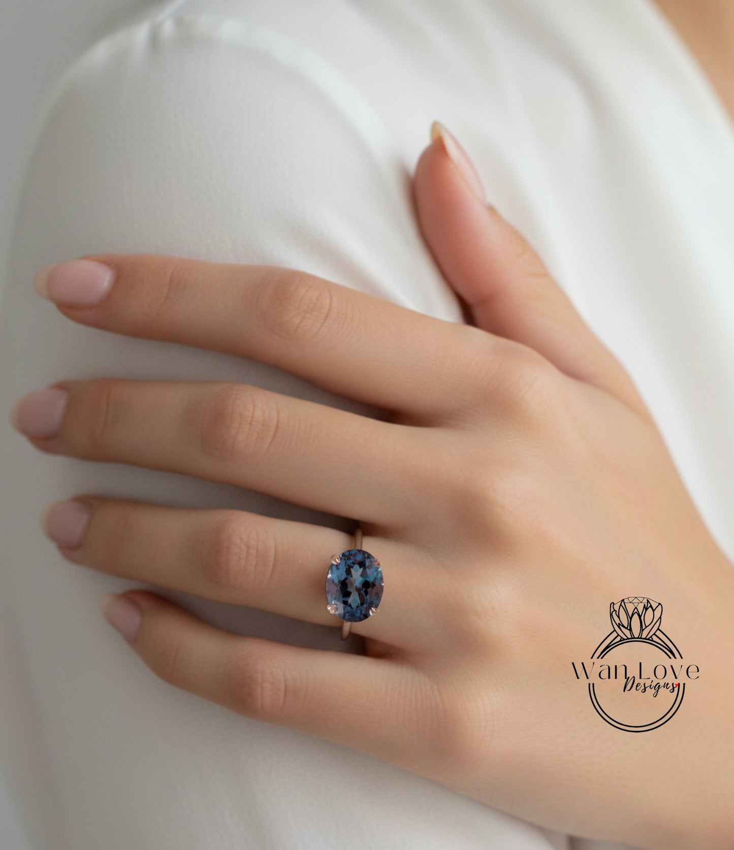 A close-up of a person's hand wearing a ring with a large blue gemstone.