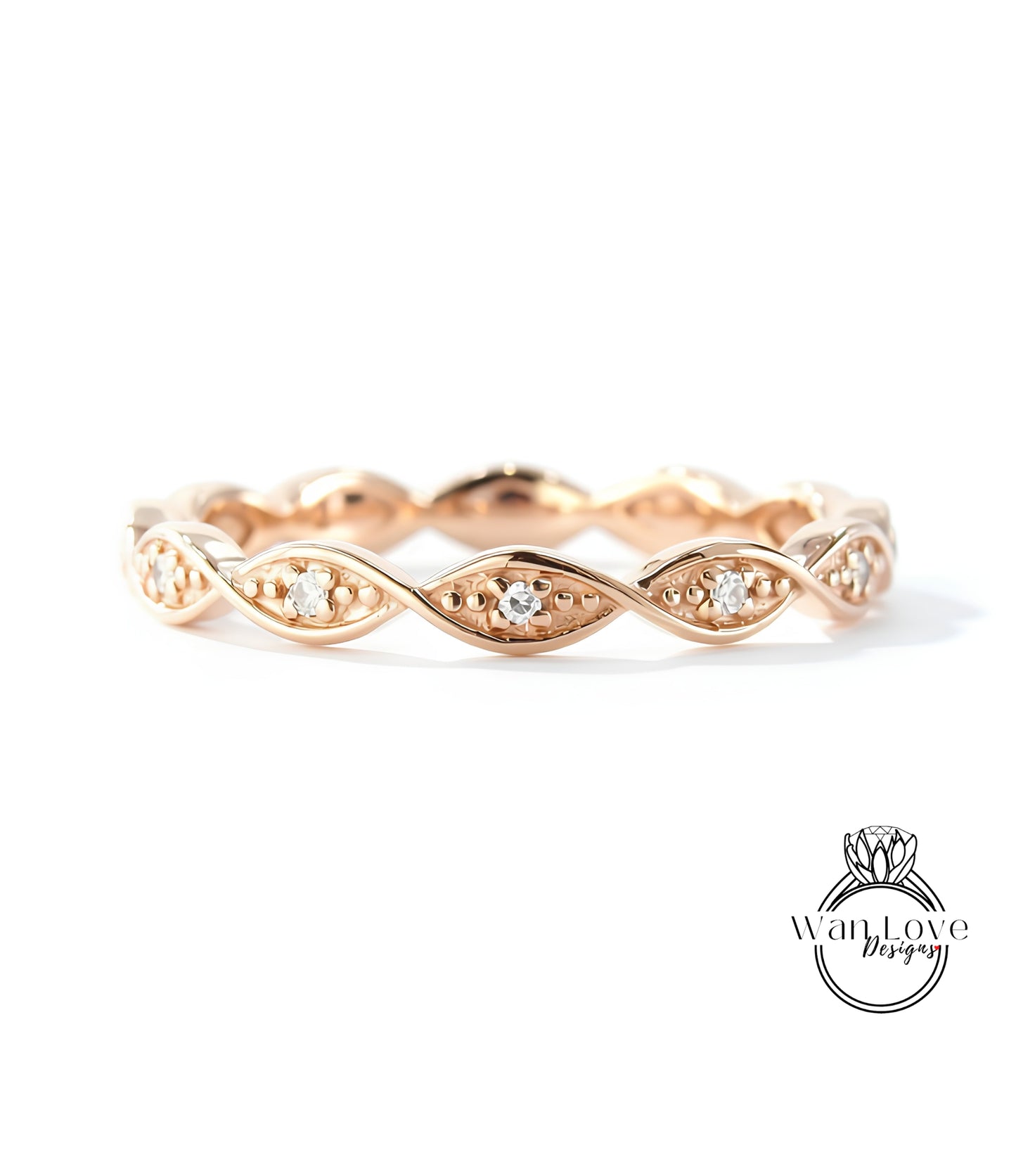 A rose gold ring with a delicate, intricate design featuring small diamonds set in a swirling pattern.