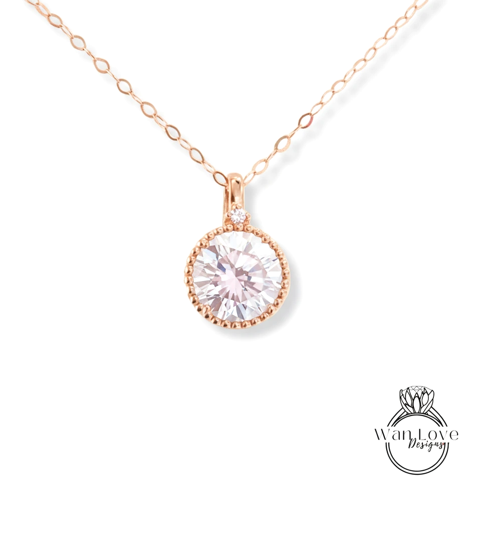 A delicate rose gold necklace with a large, round, clear gemstone pendant.