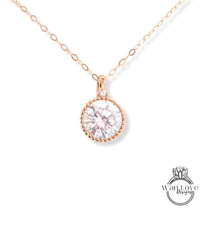 A delicate rose gold necklace with a large, round, clear gemstone pendant.
