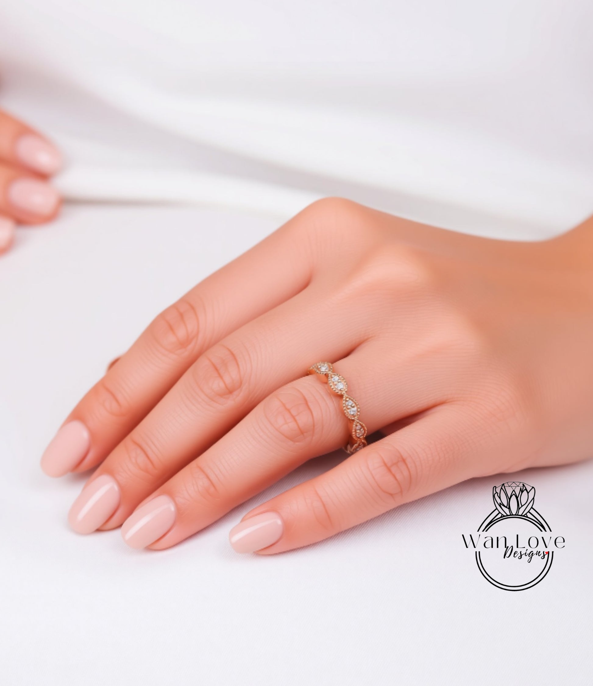 A close-up of a hand wearing a gold ring with a delicate design.