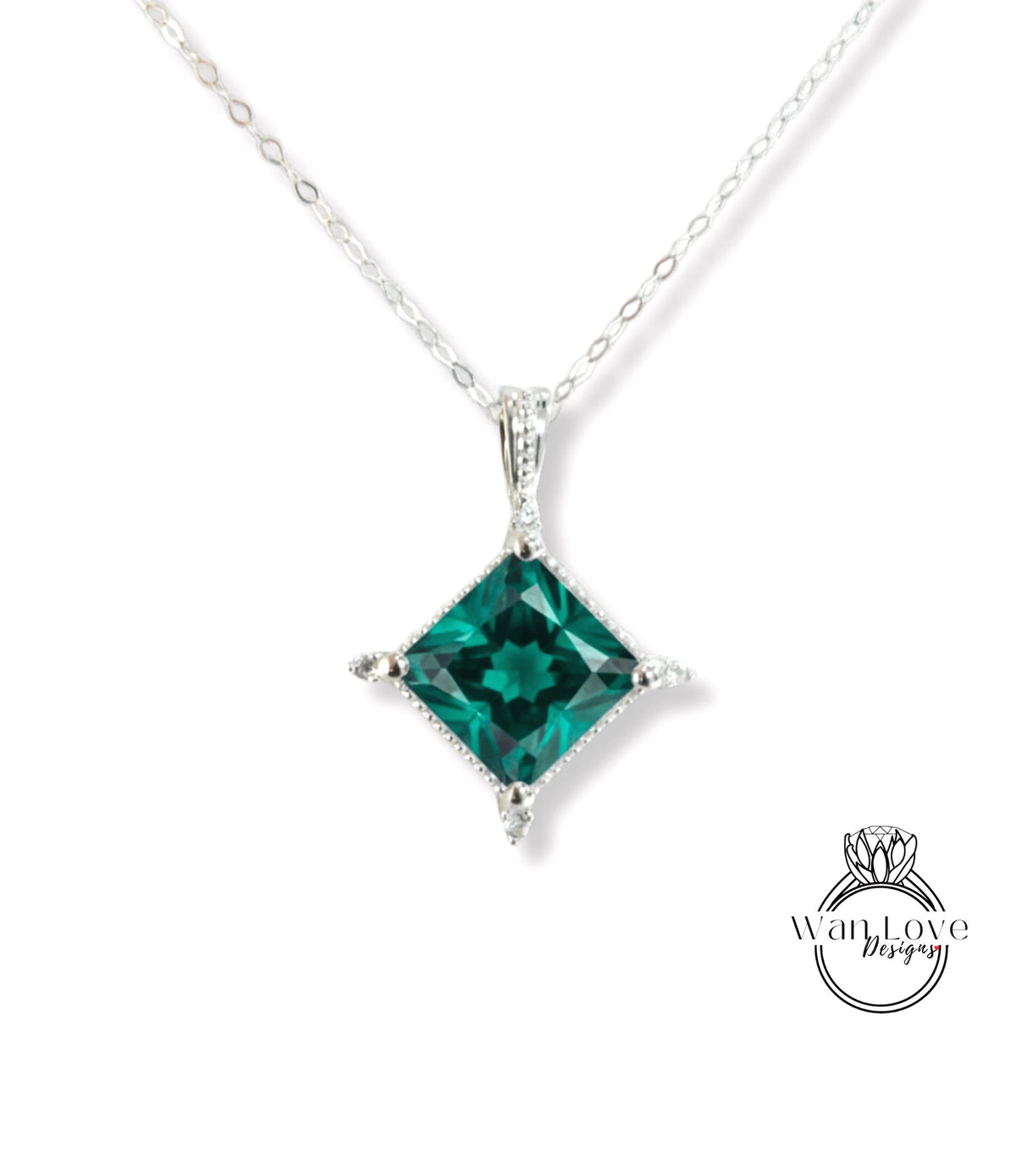 A silver necklace with a large, green gemstone pendant.