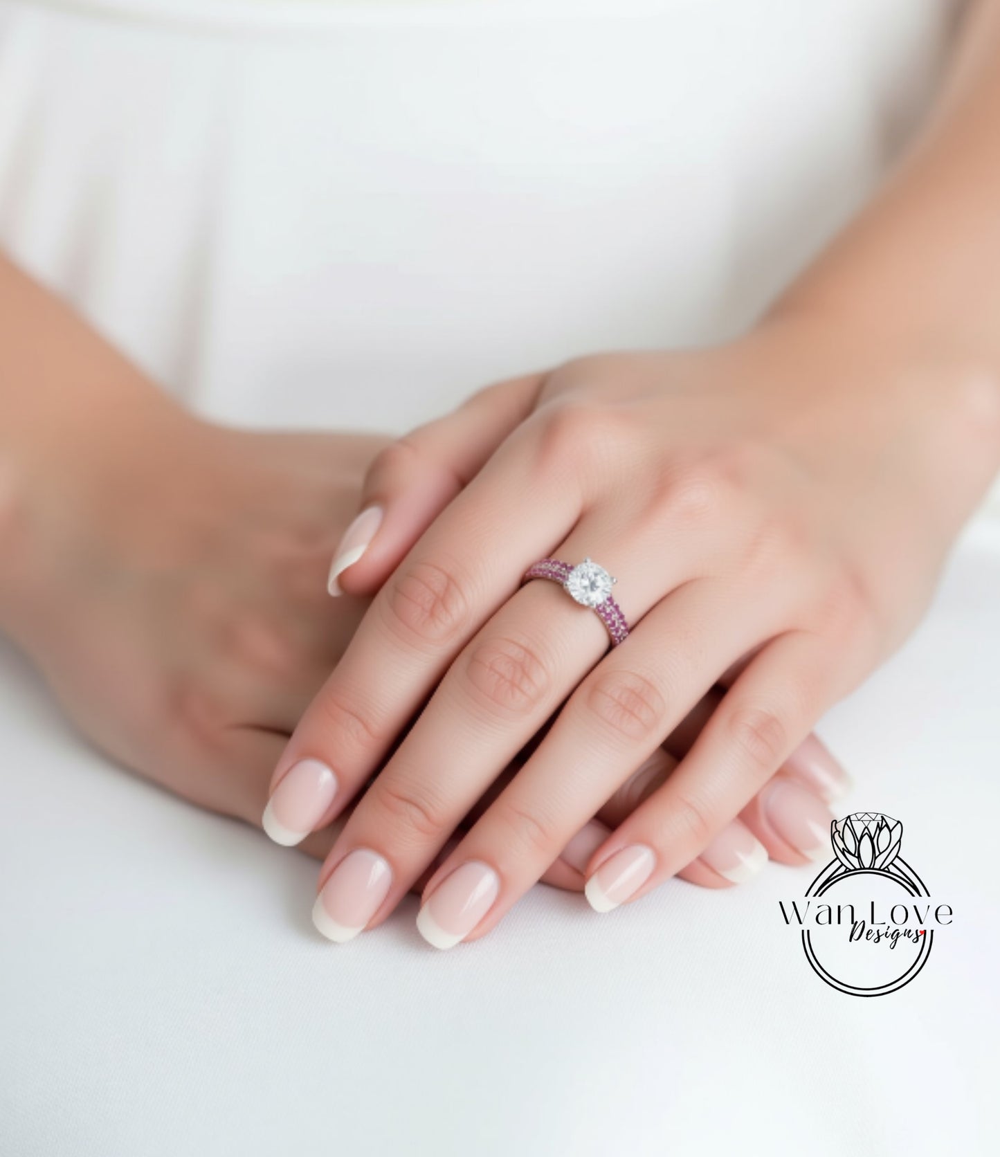 A close-up of a person's hands wearing a ring with a large diamond and a pink band.