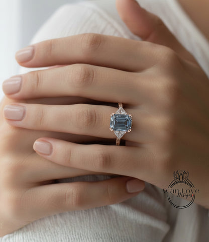 A close-up of a person's hand wearing a large, blue gemstone ring with a gold band.