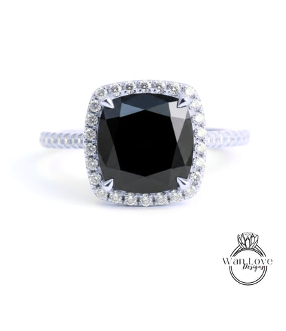 A diamond engagement ring with a large black gemstone set in a halo of smaller diamonds.