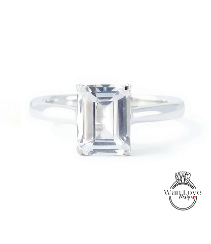 A diamond engagement ring with a large, clear gemstone set in a silver band.