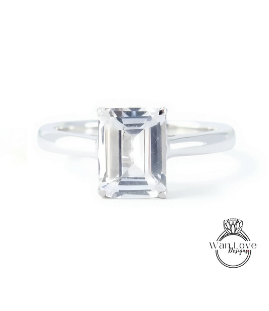 A diamond engagement ring with a large, clear gemstone set in a silver band.