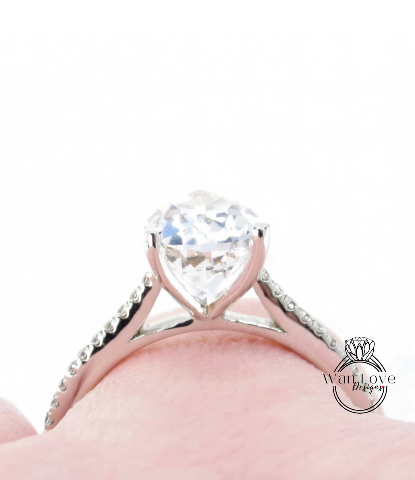 A close-up view of a diamond engagement ring on a person's finger, showcasing the sparkling center stone.