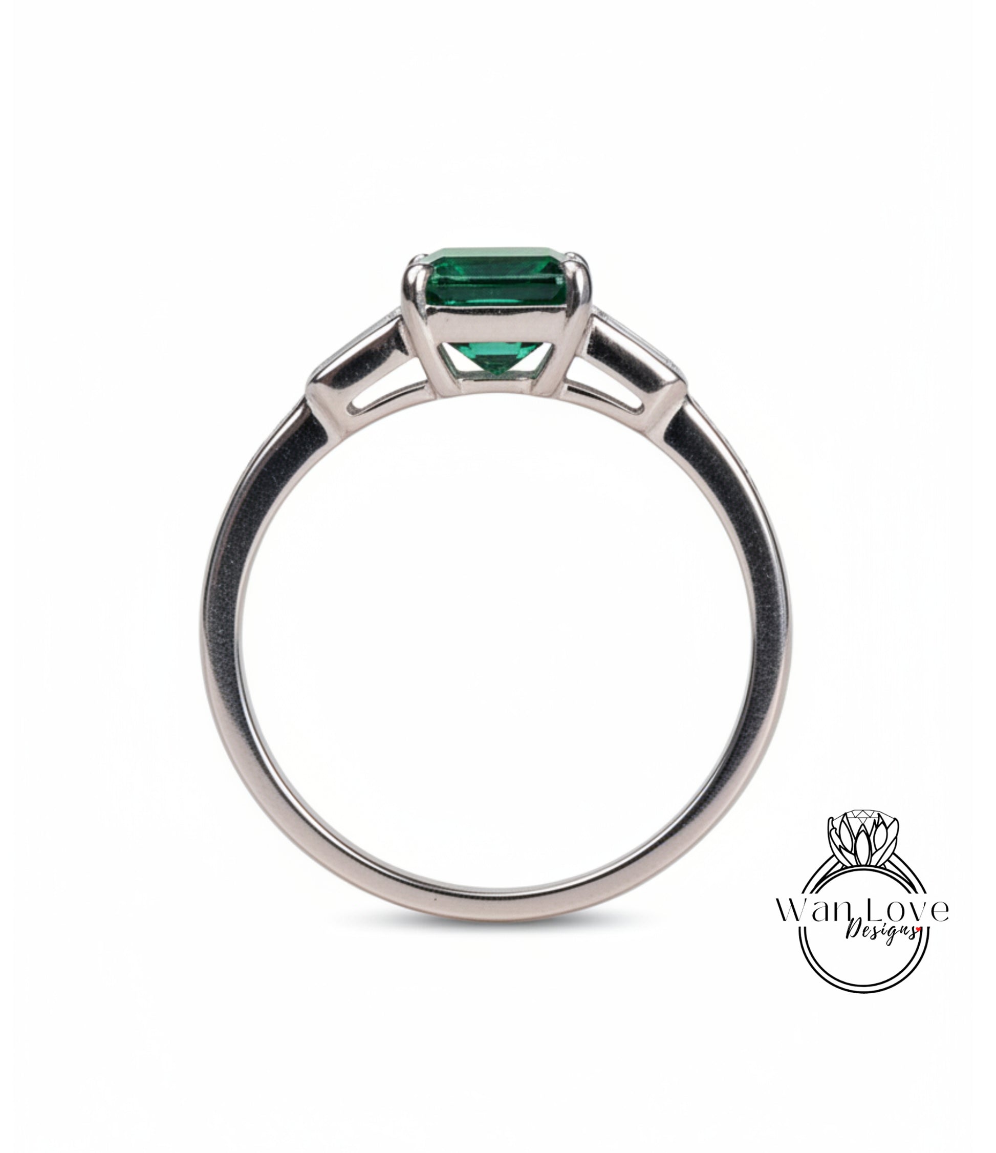 A silver ring with a large green gemstone, possibly a diamond, set in the center.