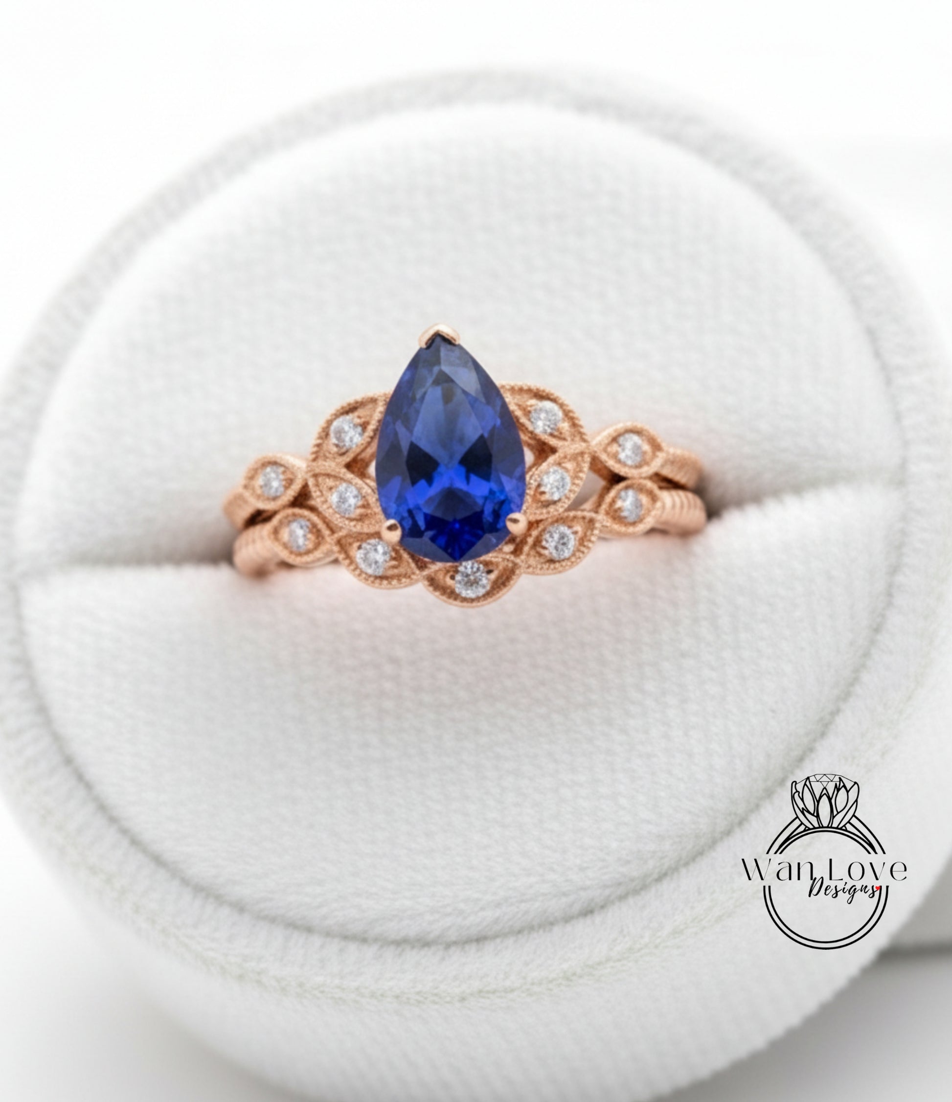 A close-up image of a gold ring with a large blue gemstone, placed in a white jewelry box.