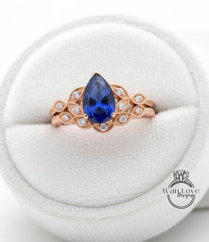 A close-up image of a gold ring with a large blue gemstone, placed in a white jewelry box.