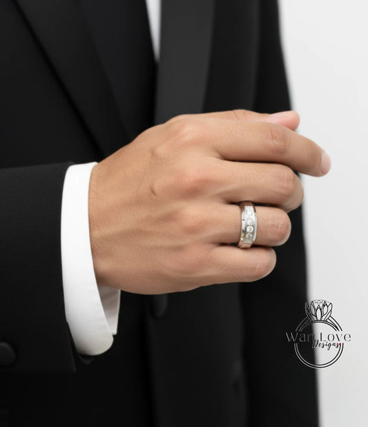 A close-up of a person's hand wearing a ring, with a black suit jacket visible in the background.