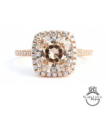 A large, round, beige diamond engagement ring with a halo of smaller diamonds around the center stone.