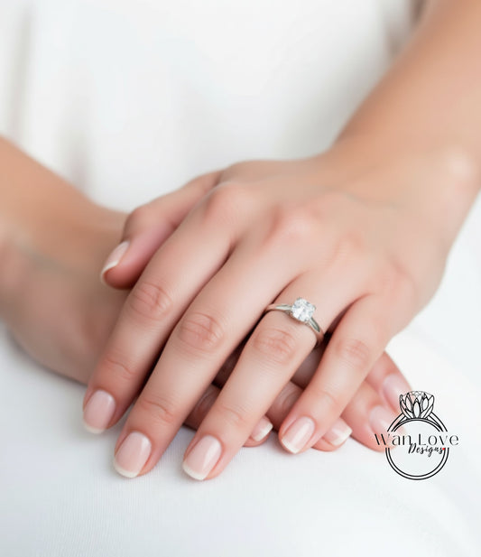 A close-up of a person's hands wearing a diamond engagement ring.