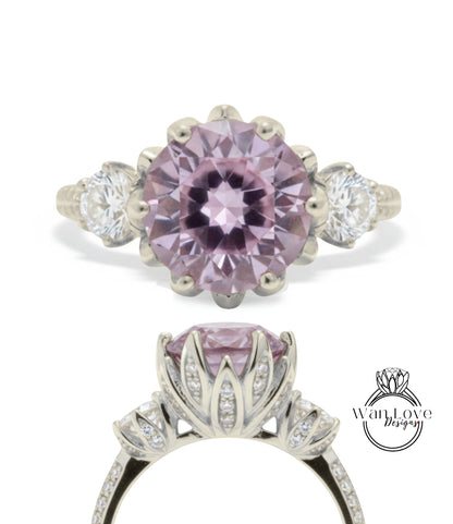 a beautiful engagement ring with a large, round purple gemstone set in a silver band. The ring is adorned with smaller diamonds and has a delicate floral design around the gemstone.