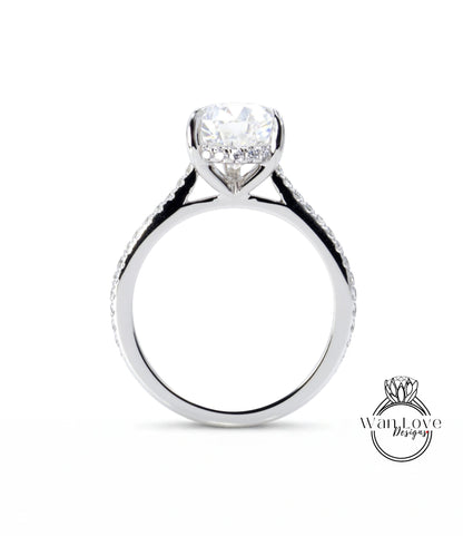 A close-up view of a silver engagement ring with a large central diamond and smaller diamonds along the band.