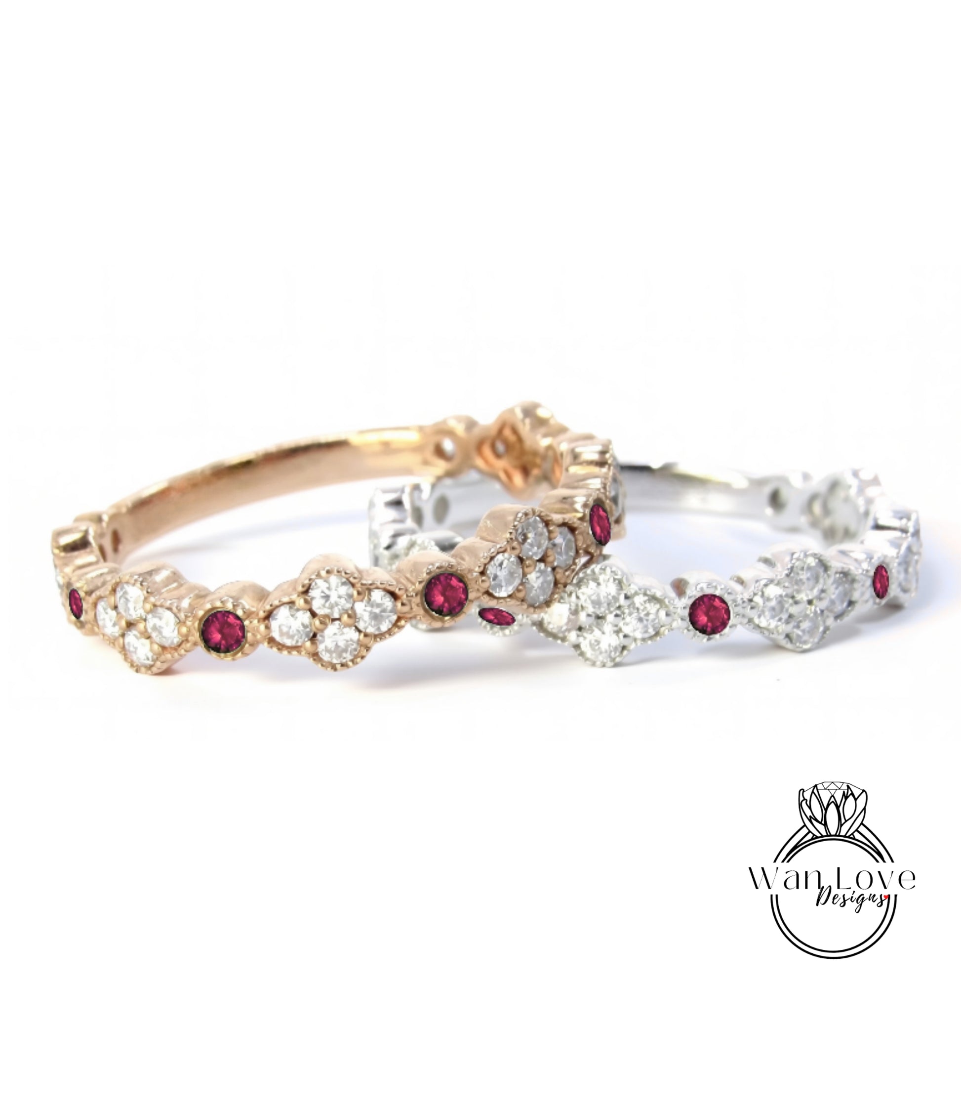 two ornate rings with gemstones, one in gold and the other in silver, both featuring a floral design and red gemstones.