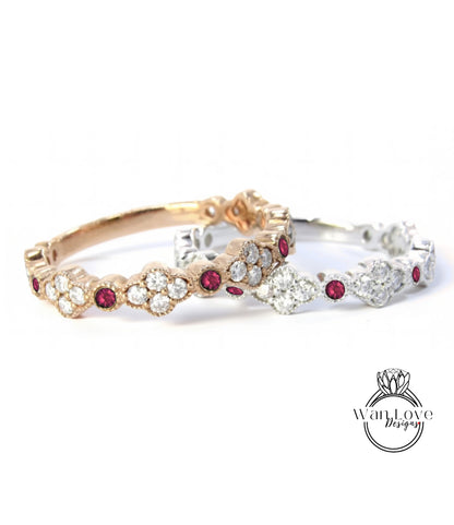 two ornate rings with gemstones, one in gold and the other in silver, both featuring a floral design and red gemstones.