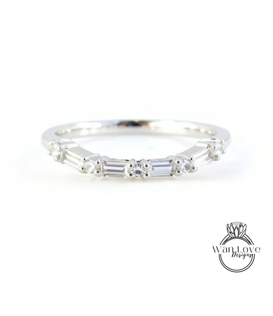 A silver ring with a row of small diamonds set in the band.