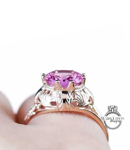 A close-up view of a person's hand wearing a gold ring with a large, round pink gemstone.