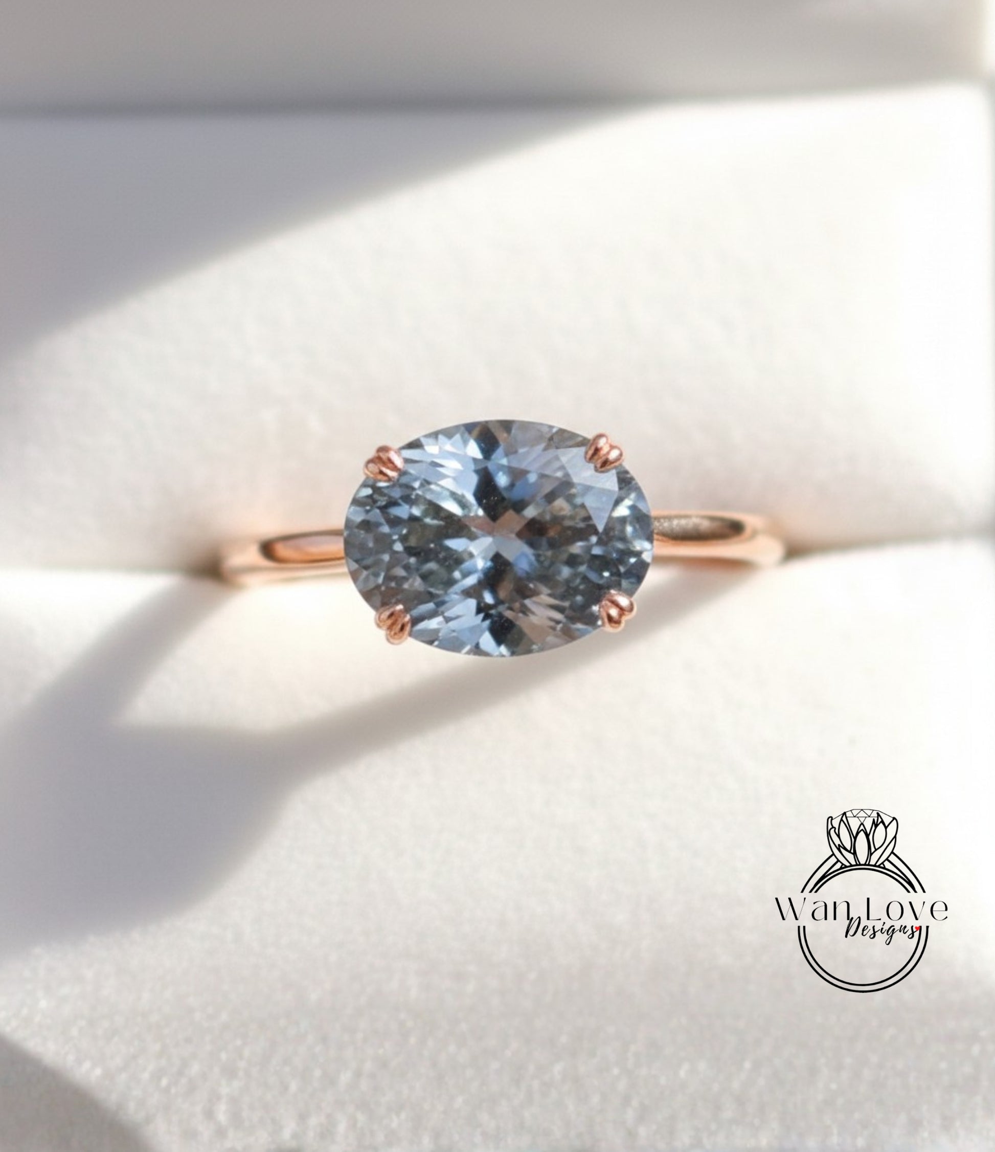 A close-up image of a gold ring with a large blue gemstone, placed on a white background.