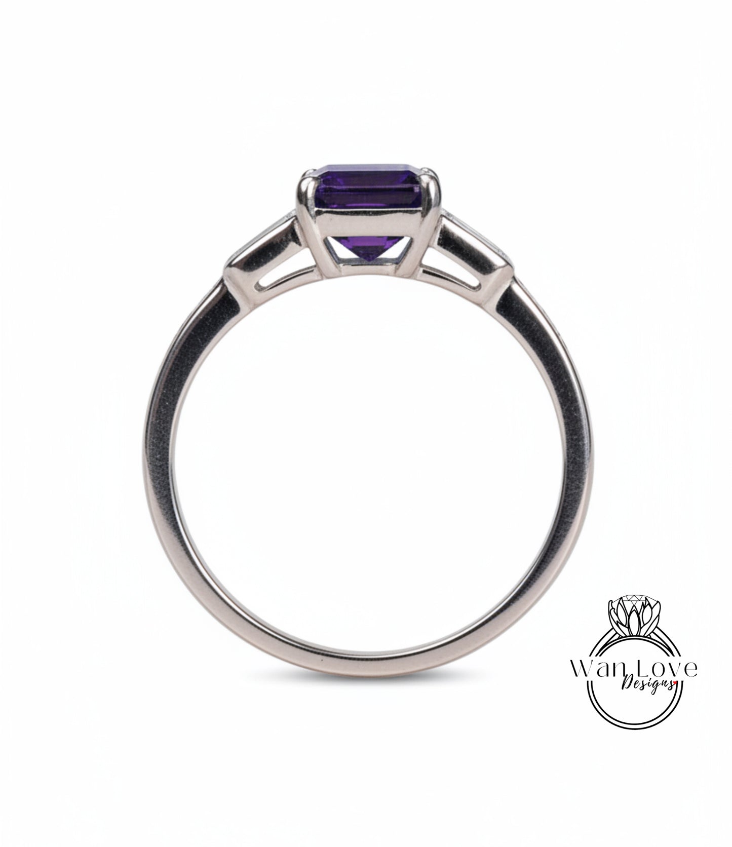 A silver ring with a large purple gemstone, likely an amethyst, set in the center.