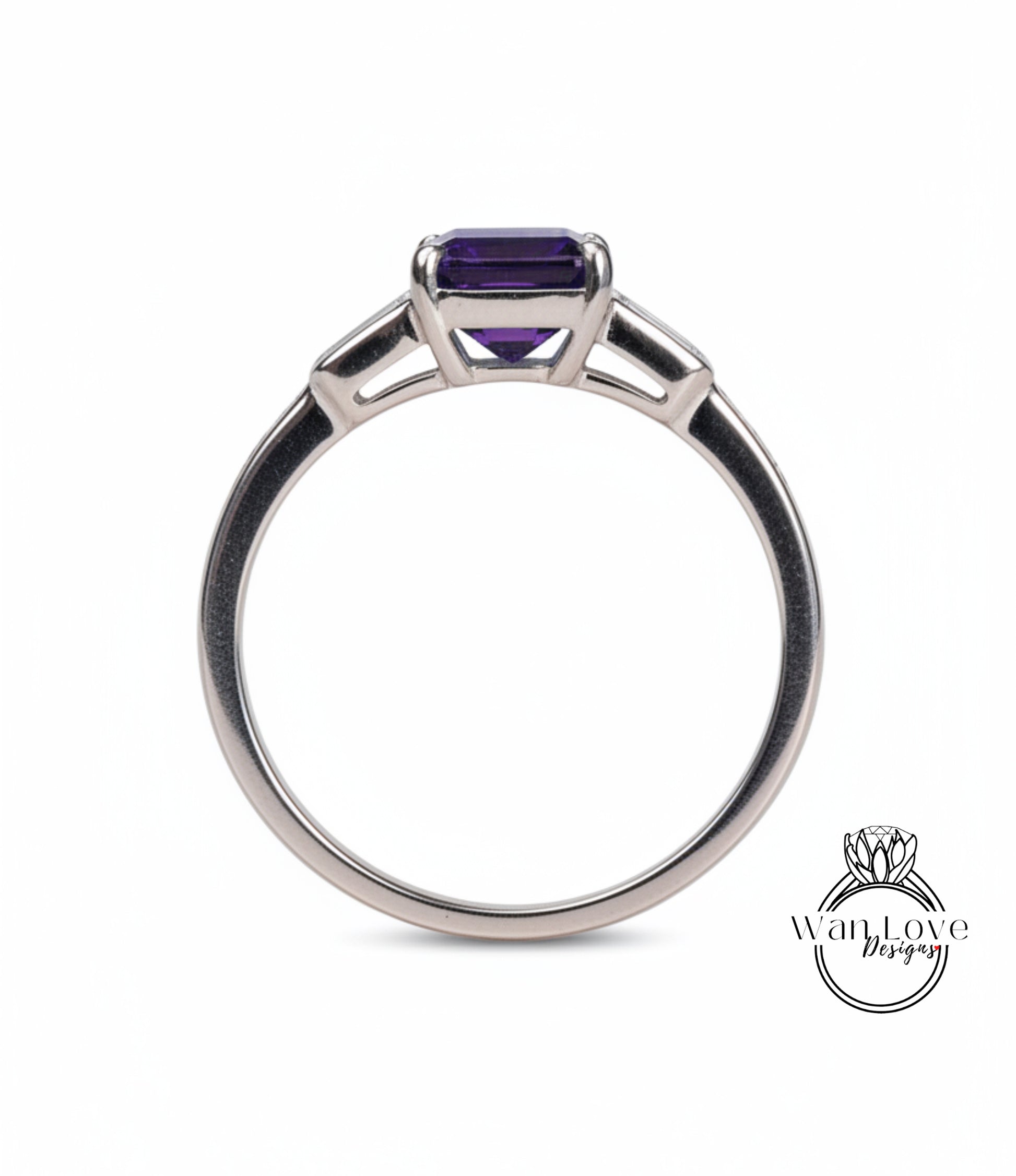 A silver ring with a large purple gemstone, likely an amethyst, set in the center.