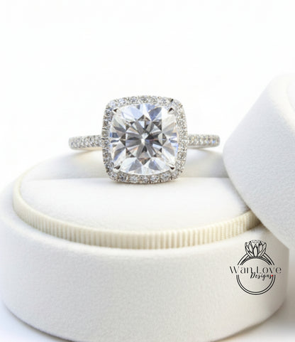 A large, clear diamond engagement ring with a halo of smaller diamonds around the center stone, displayed in a white jewelry box.