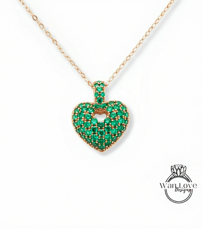 A necklace with a heart-shaped pendant made of green gemstones, possibly emeralds.