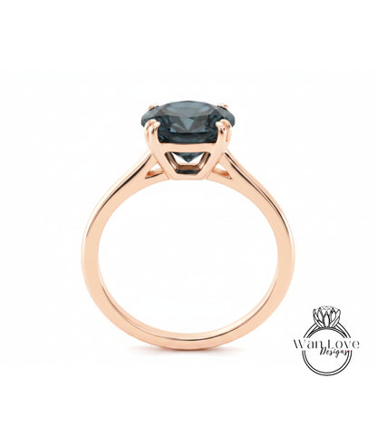 A rose gold engagement ring with a large blue gemstone set in the center.