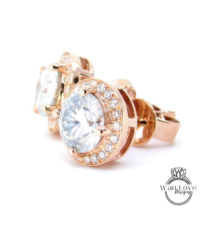 A pair of elegant gold earrings with large, clear gemstones set in a halo-like design.