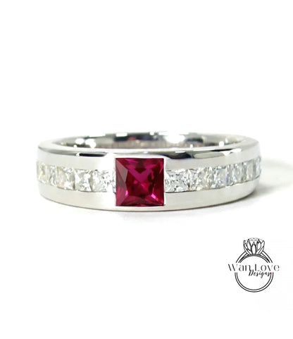 A silver ring with a large red gemstone in the center, surrounded by smaller diamonds.