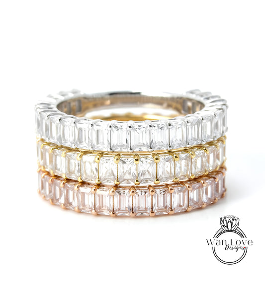 A stack of three rings, each with a row of clear gemstones, showcasing the rings in different colors.