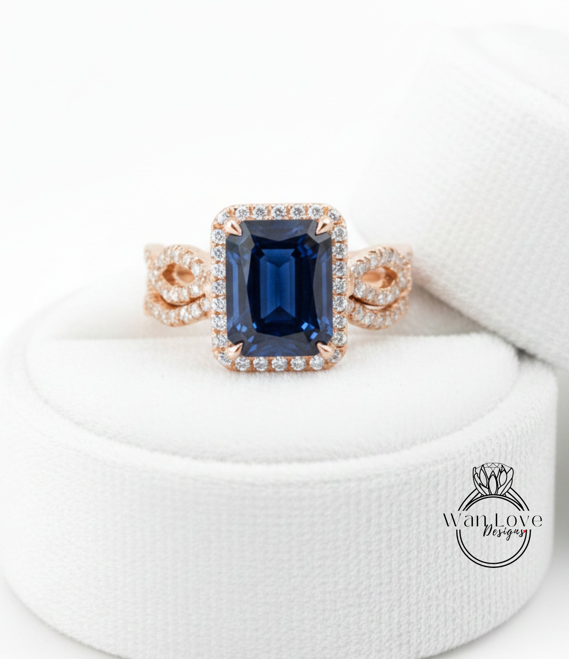 A close-up image of a gold ring with a large blue gemstone, placed on a white cloth.
